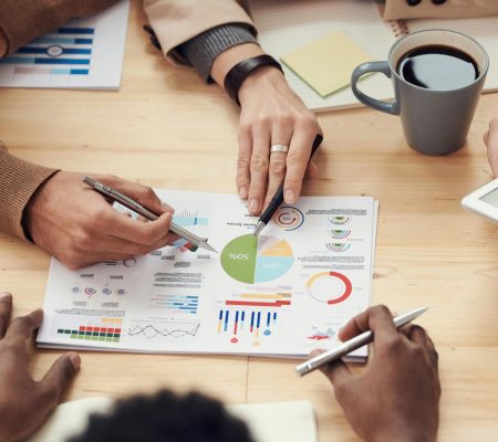 Colleagues discussing data and strategy in an office meeting.