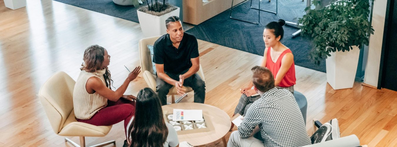 A diverse group of professionals engage in a collaborative team meeting in a stylish office environment.